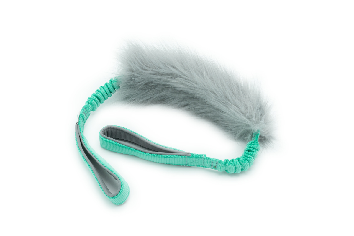 Afbeelding van het Yuna hondenspeeltje met grijs imitatiebont, twee muntkleurige elastische handvatten, en een zachte grijze binnenkant.