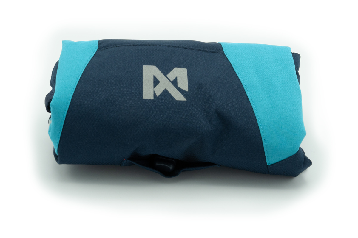 Foto van een opgevouwen hondenjas, zodat deze in de compressiezak past. Het is de Glacier 2.0 winterjas van Non-stop dogwear in de kleur blauw.