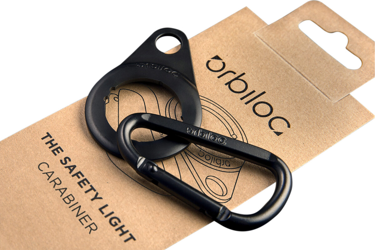"Productfoto van de Orbiloc Carabiner en mount voor de Orbiloc Safety Light, inclusief verpakking, op een witte achtergrond