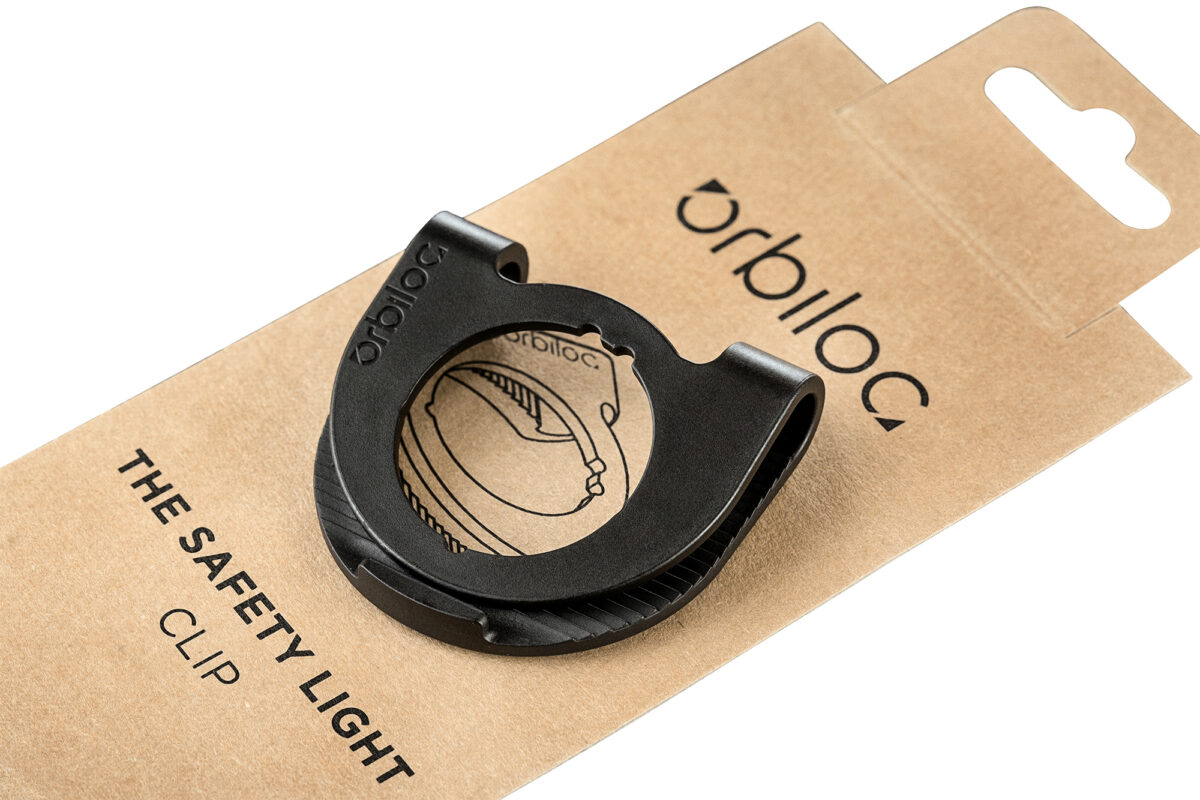 Productfoto van de Orbiloc Clip met verpakking op een witte achtergrond