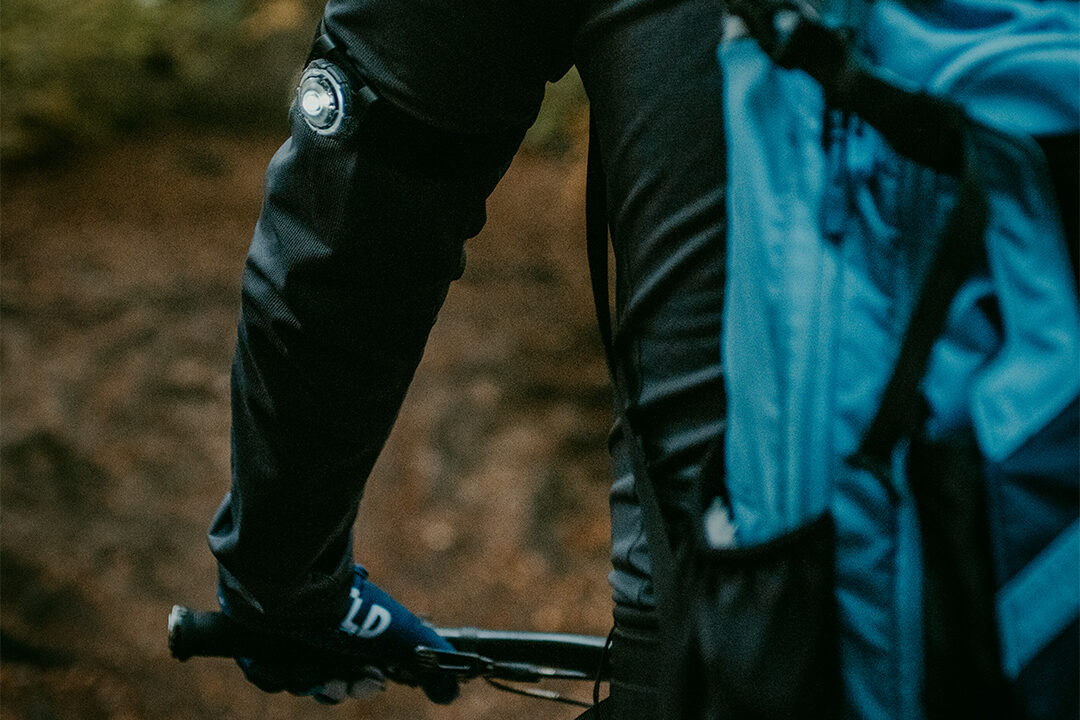 Fietser met Orbiloc sports kit (armband en clip) en koud wit veiligheidslicht.