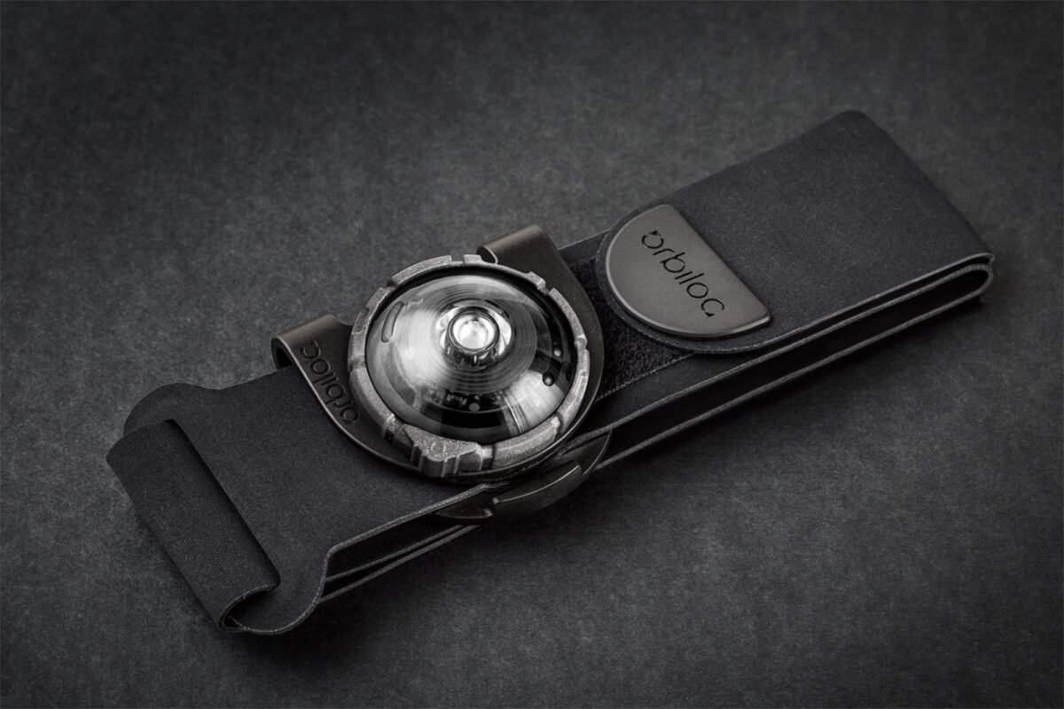 Orbiloc armband met gemonteerde clip en koud wit veiligheidslicht op een zwarte achtergrond.