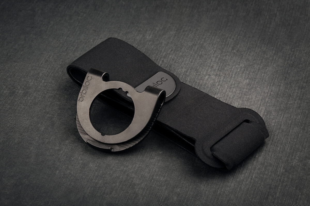 Orbiloc armband en clip op een donkere achtergrond.