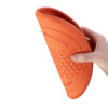 Een hand vouwt de flexibele Flying Disk frisbee voor honden dubbel.