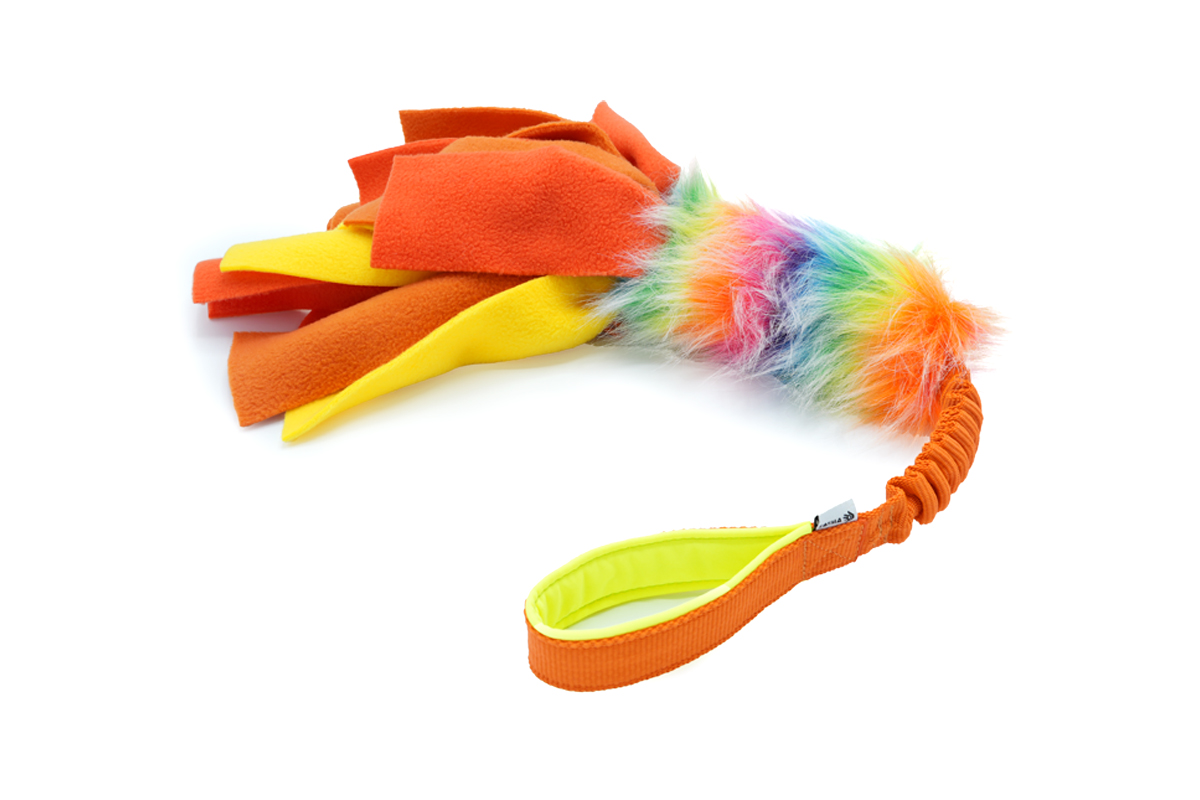 Hondenspeeltje in meerdere kleuren: fleece stroken in het oranje en geel, een middenstuk van imitatiebont in regenboogkleuren en een elastisch en zacht handvat in geel en oranje.