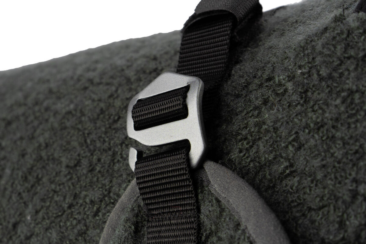 Detailfoto van de aluminium gesp aan de wollen hondenjas.
